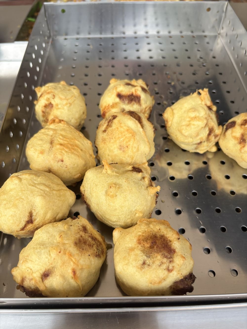 Freshly fried items resting on a steel tray